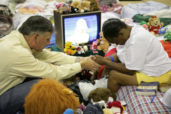 Franklin Graham praying with a Hurricane Katrina survivor in 2005.