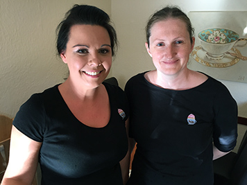 Dawn and Sharon stand side by side in tearoom