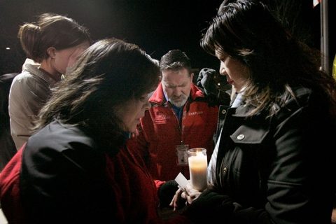 Chaplains pray with locals in Monterey Park, Calif., during a candlelight vigil at City Hall following a shooting at a dance studio.