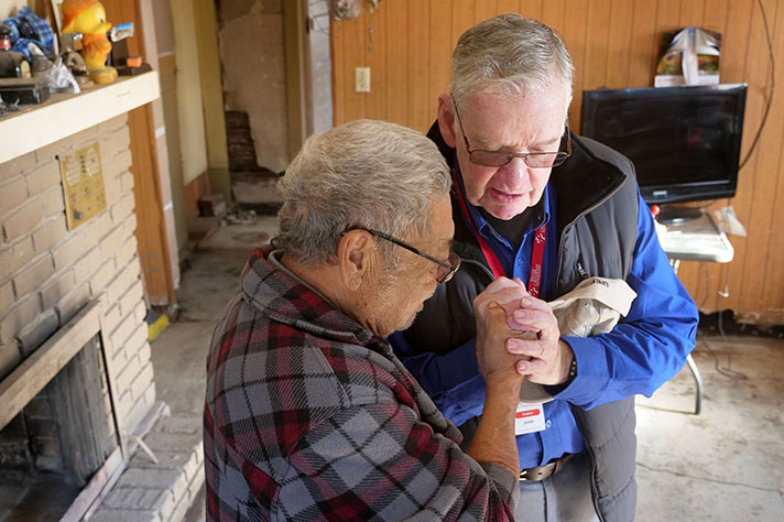  Billy Graham chaplain John Garner prays with a man whose home was damaged in the floods in Merced County, California.	