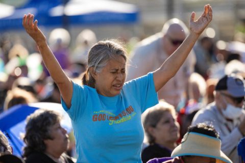 A woman raises her hands to heaven at the kick-off event of the God Loves You Frontera Tour