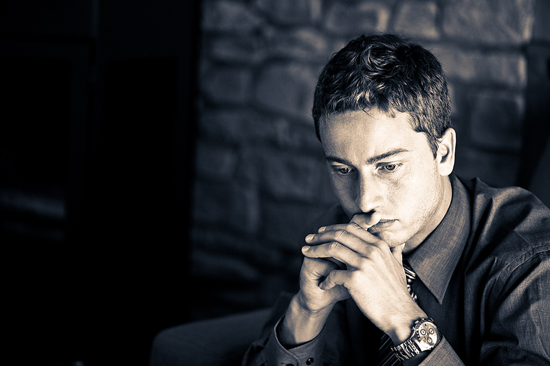 man sits, contemplating