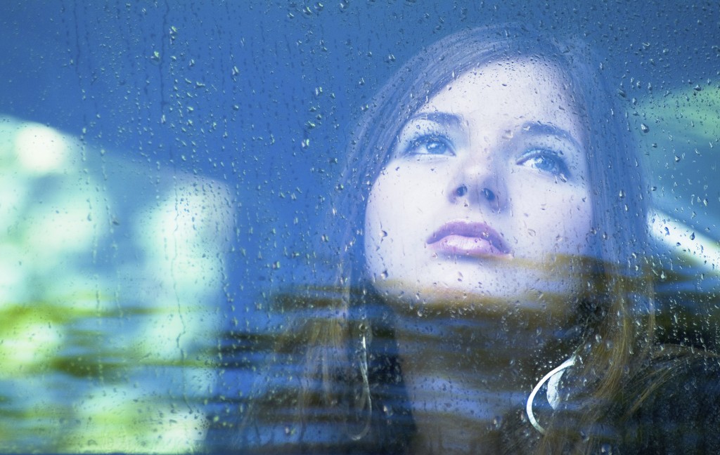 girl looking out of window, raining