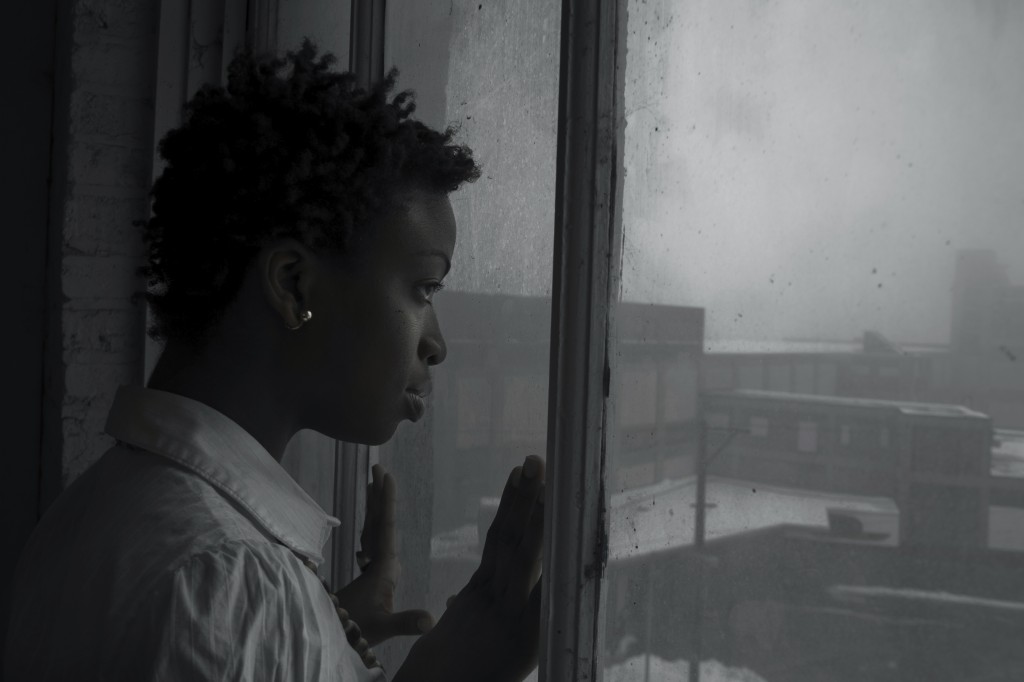 woman looking out window on dark day