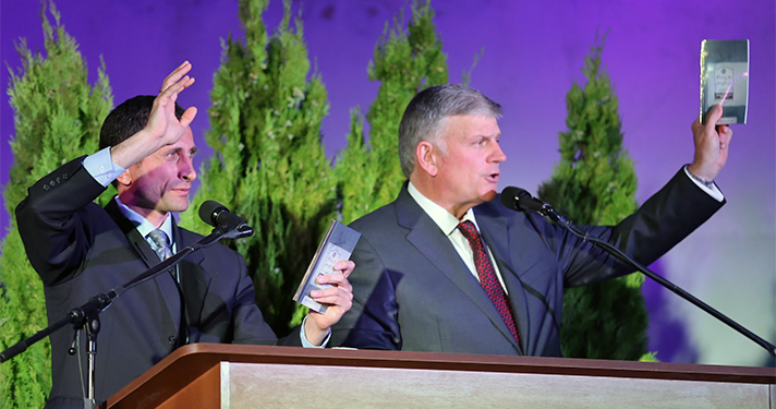 Franklin Graham holds up Georgian discipleship materials given to all new believers.