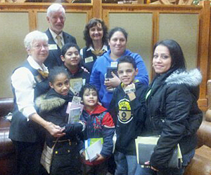 A mom (in blue) and her four children accepted Christ during Christmas at the Library, thanks to an invitation from a family friend (front right).