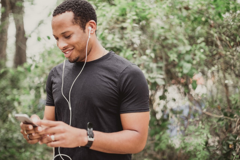 young man listening to podcast on his phone