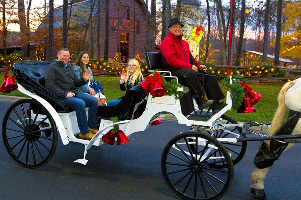 People ride in a horse-drawn carriage