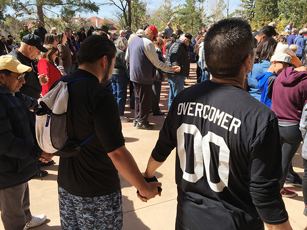 Men holding hands in prayer