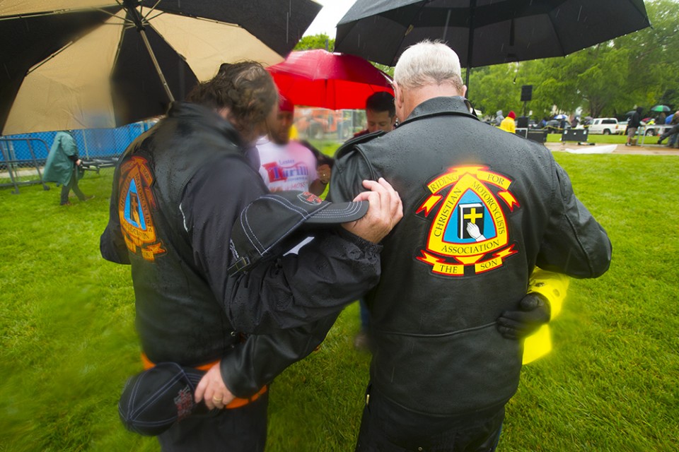 Men in motorcycle jackets praying