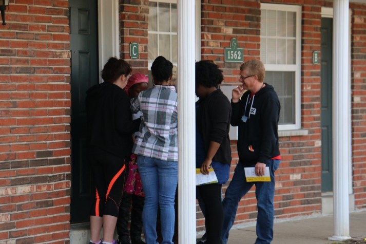 Volunteers visit with a resident in the Ferguson community during an Adopt-A-Block outing.