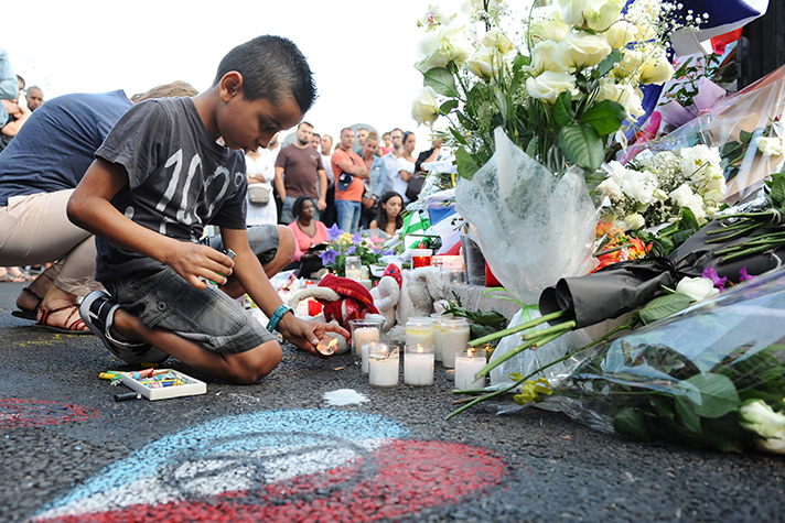 boy lights candle in Nice