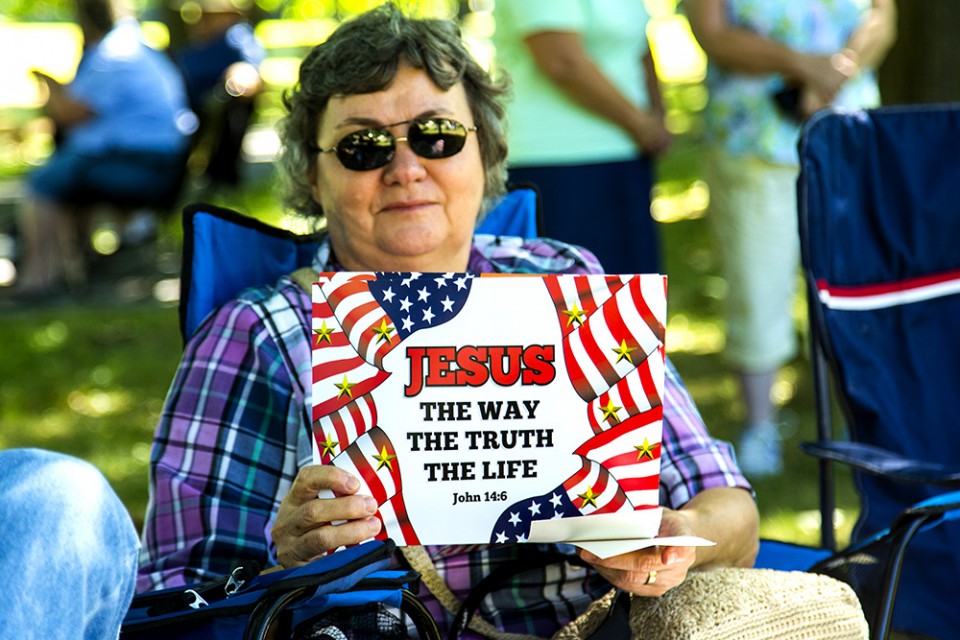 Woman with "Jesus is the way" sign