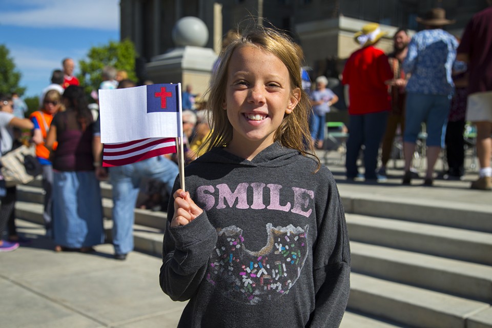 girl holding flag, smiling