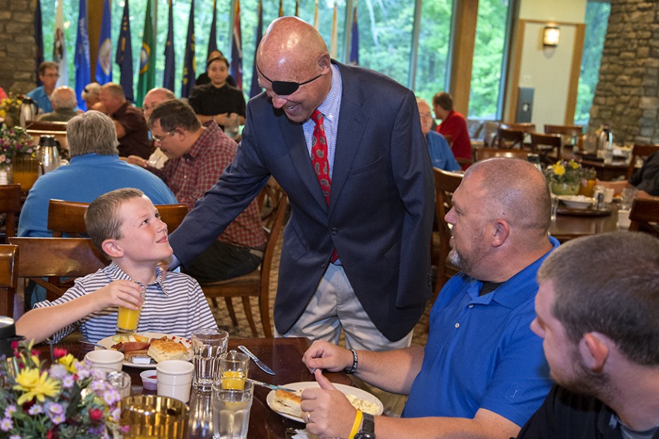 Guest speaker Clebe McClary greets young boy during breakfast