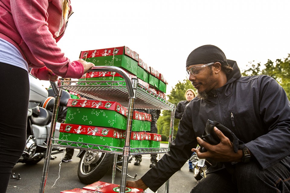 Biker placing box at bottom of cart full of boxes