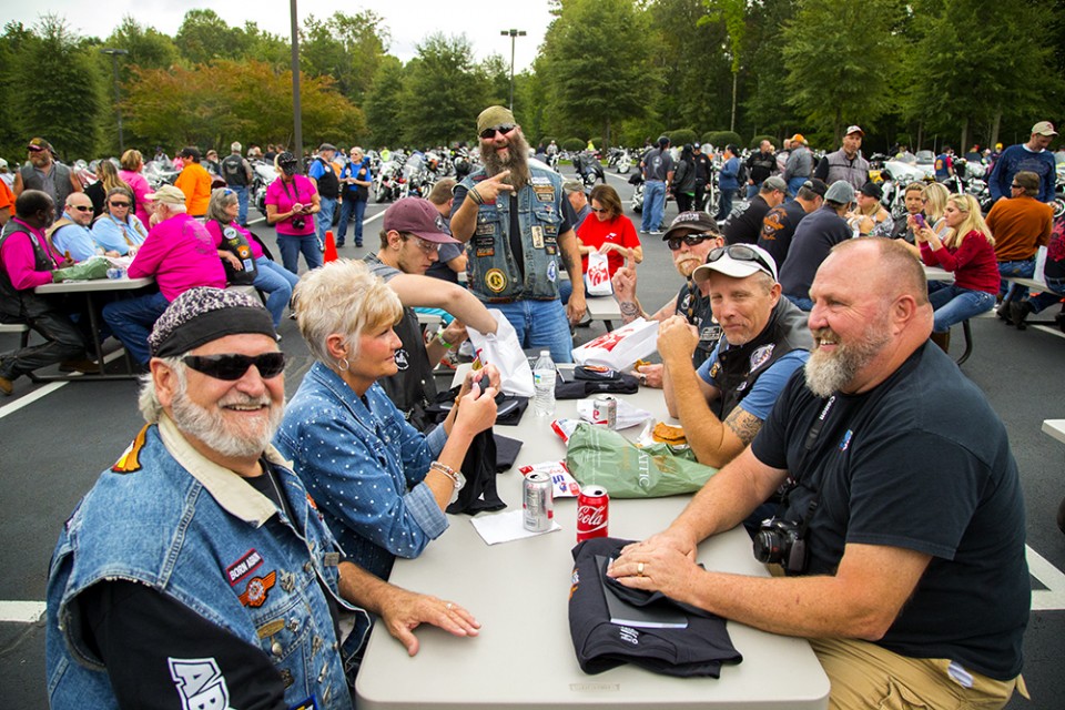 Bikers sitting around a table, smiling