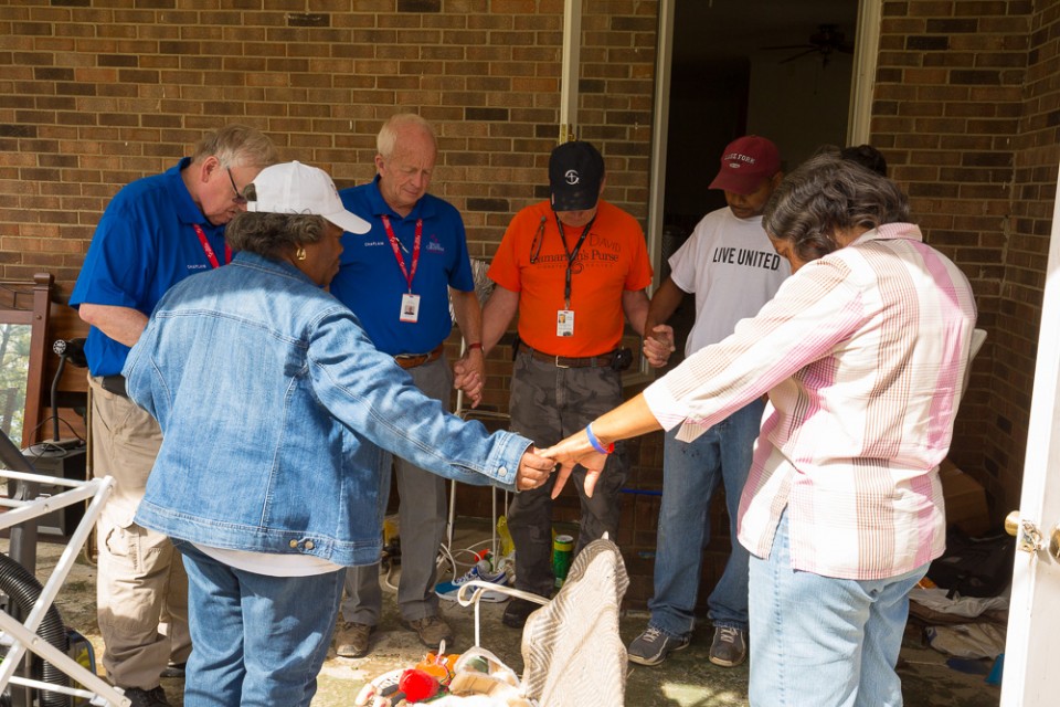 RRT chaplains circled up, holding hands with flood victims, praying
