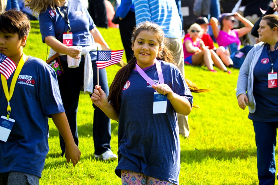 Young girl, a volunteer, holding American flag