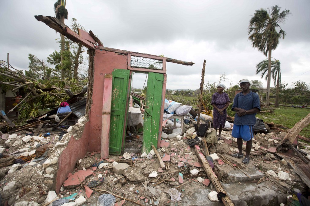 couple standing in ruins of home in Haiti
