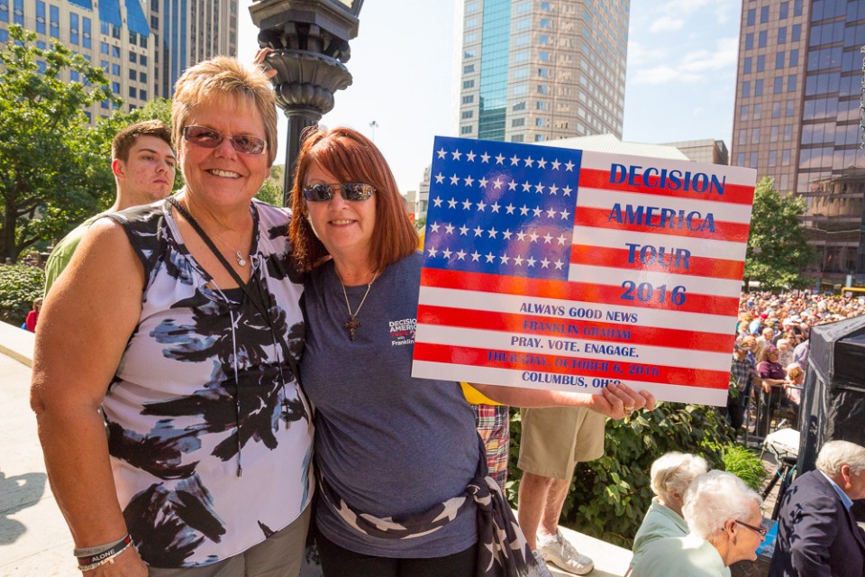 Two women. Sign that looks like Amerian flag
