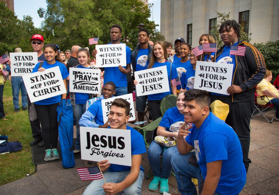 Teenagers holding "Jesus" signs