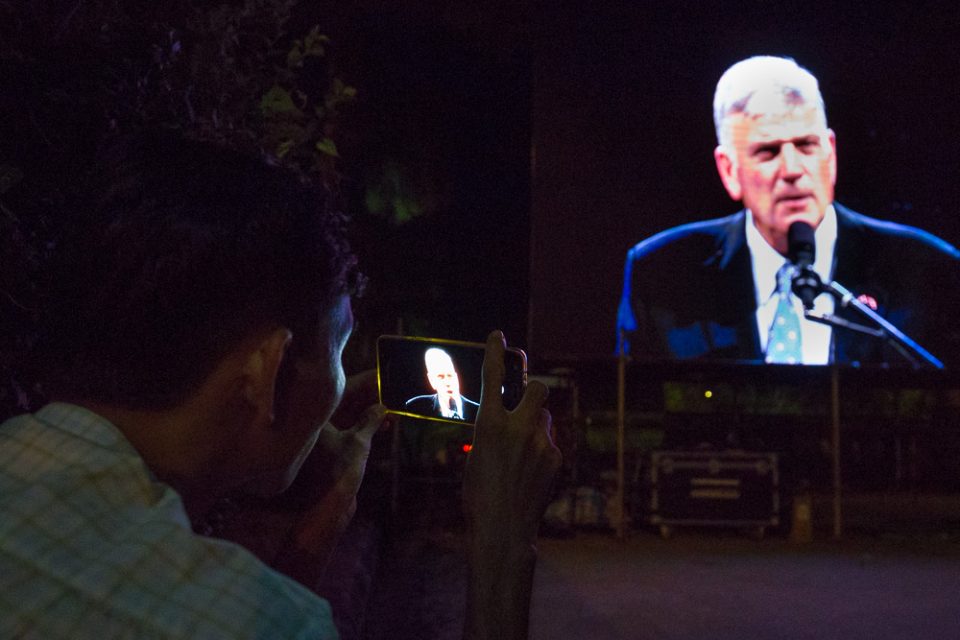 Man recording Franklin Graham's message on cell phone