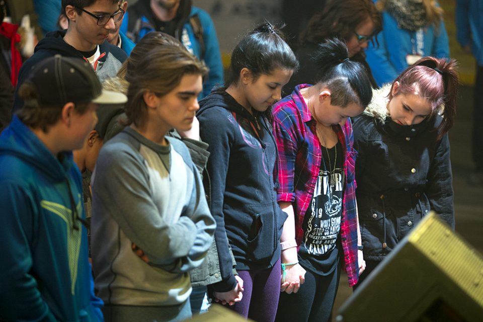 Young girls standing, holding hands and praying