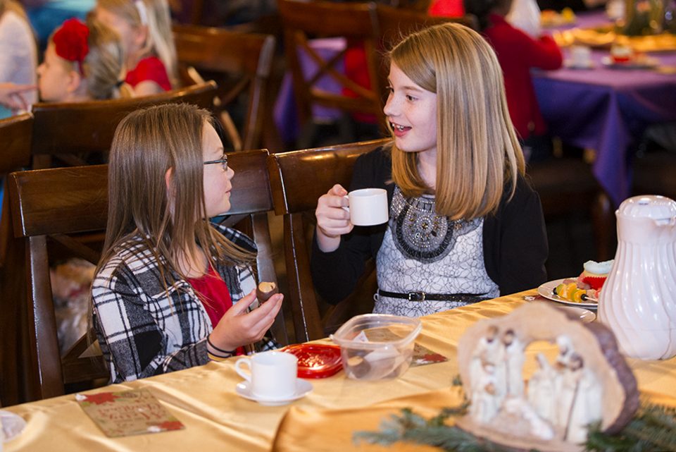 Two girls talking, eating treats, drinking hot chocolate
