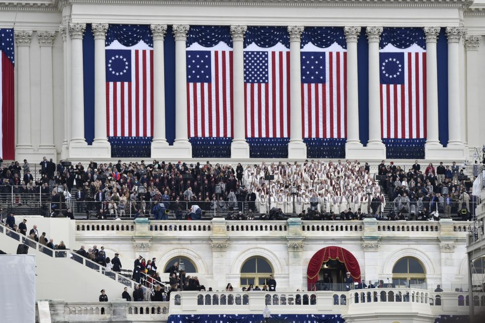 Large flags hanging between pillars of Capitol