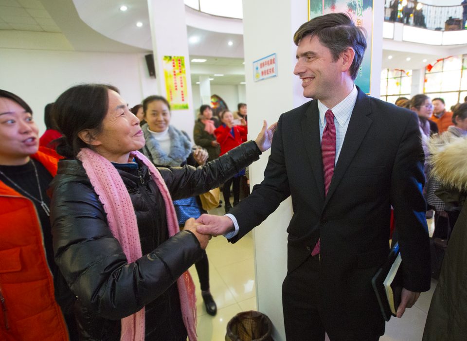 Woman shakes Will Graham's hand and welcomes him