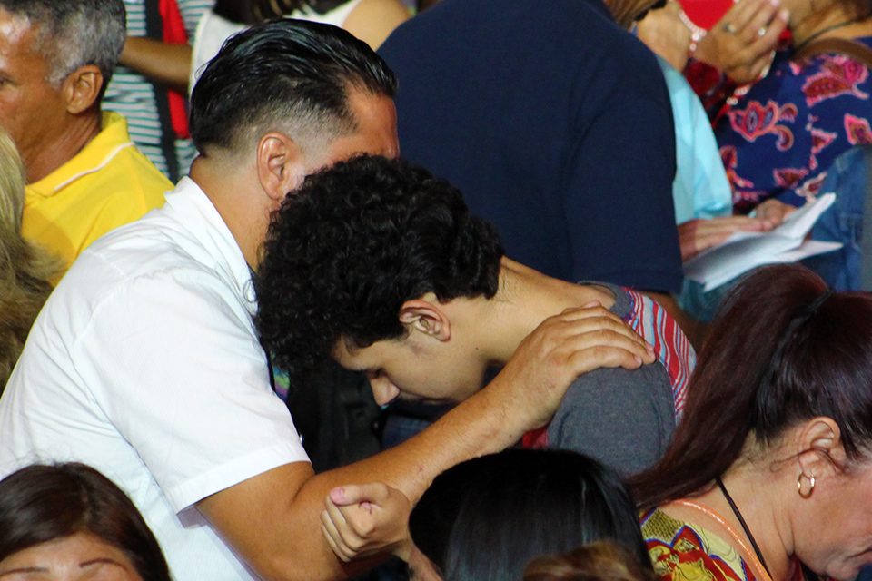Man praying over younger man
