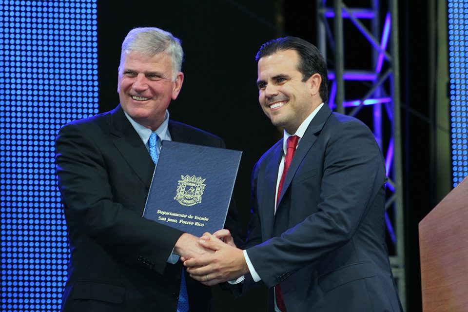 Franklin Graham holds certificate and shakes hands with Puerto Rican Gov. Ricardo Rosselló Nevares