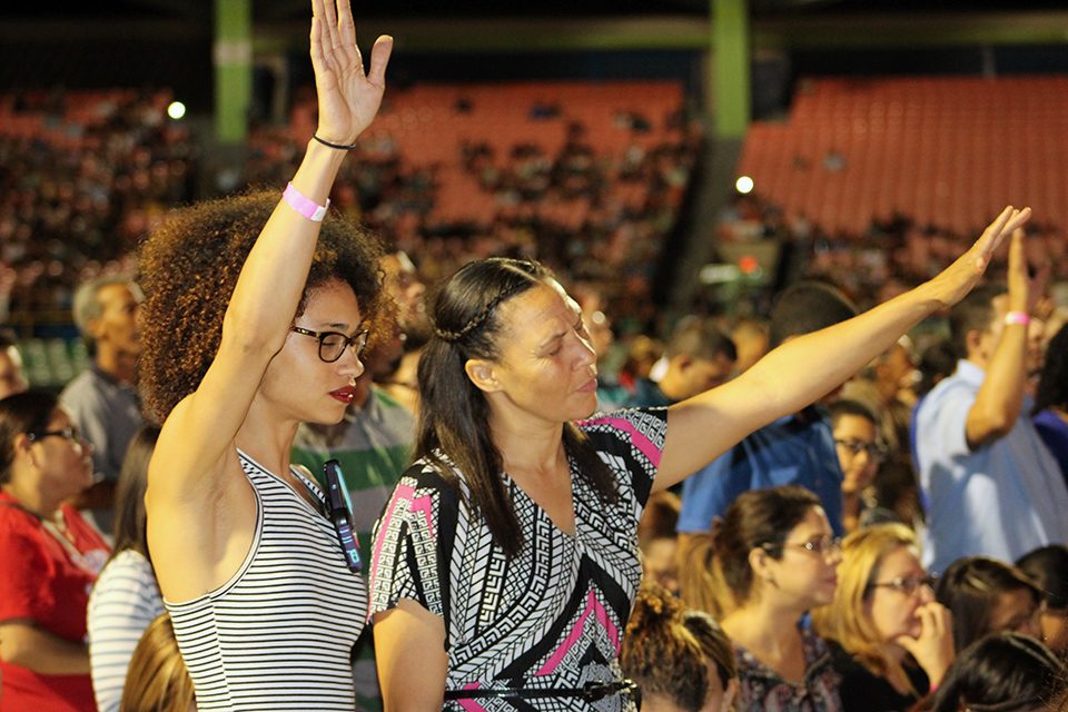 Two women raising hands in worship