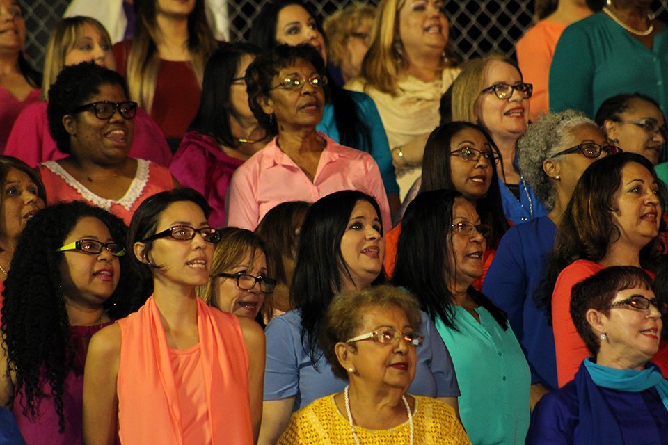 Women in colorful shirts singing