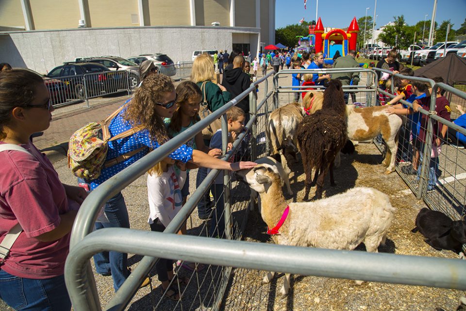 People petting farm animals at FunFest before KidzFest