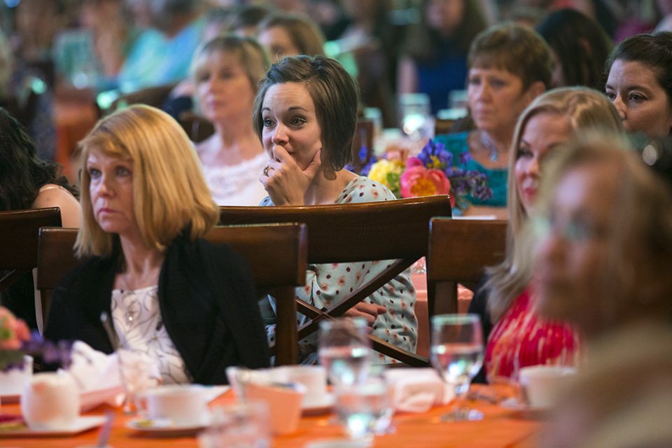Woman intently listening to message; other women listening