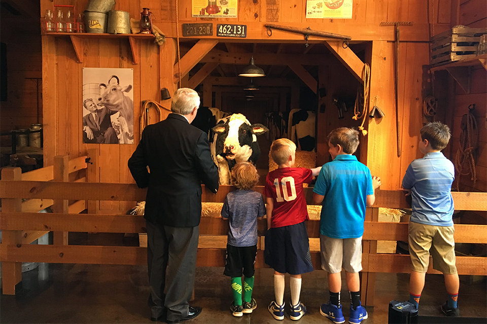 Wayne Atcheson with four grandsons listening to Bessie, an animated cow