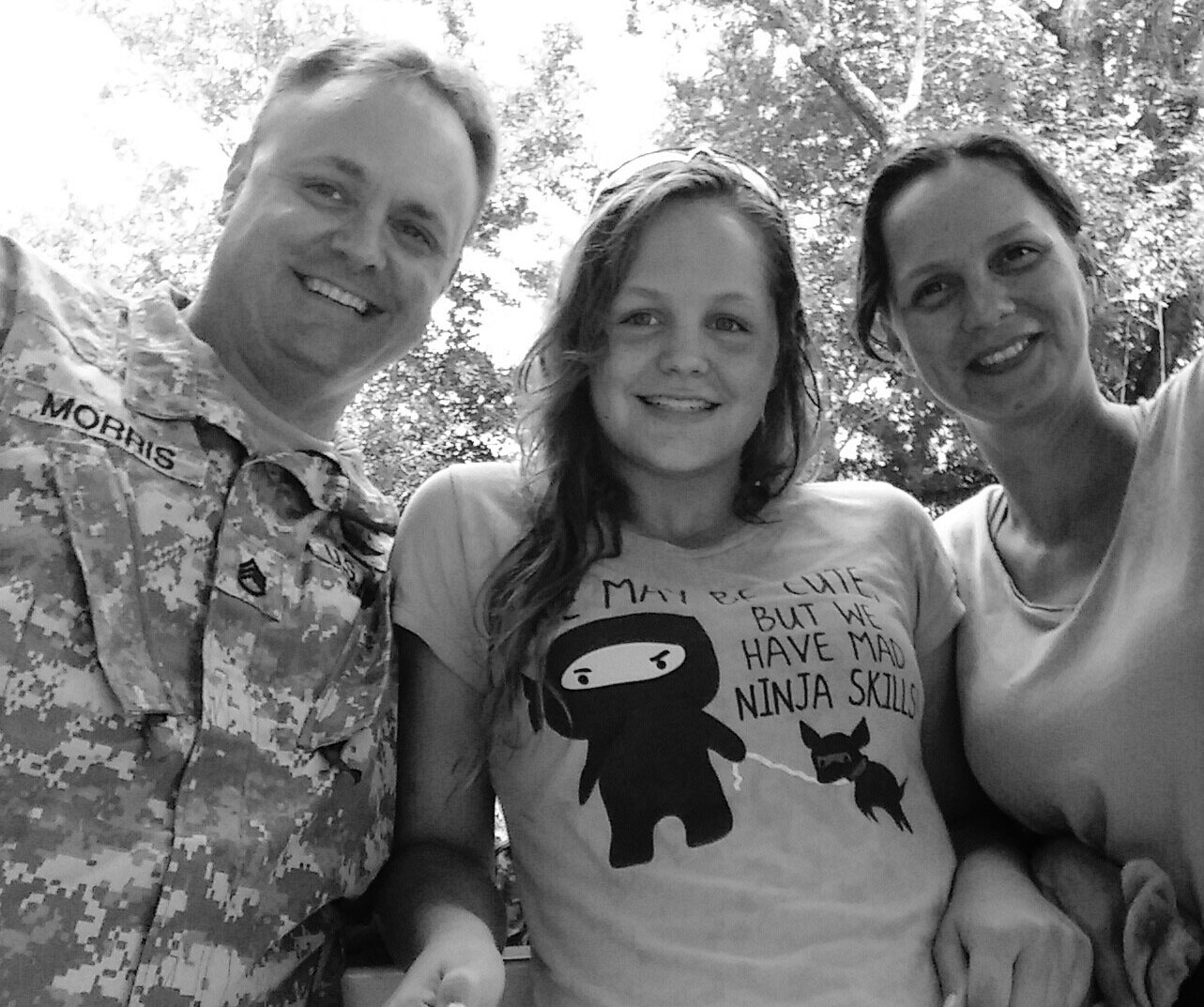 Dad, daughter and Mom sitting side by side, smiling