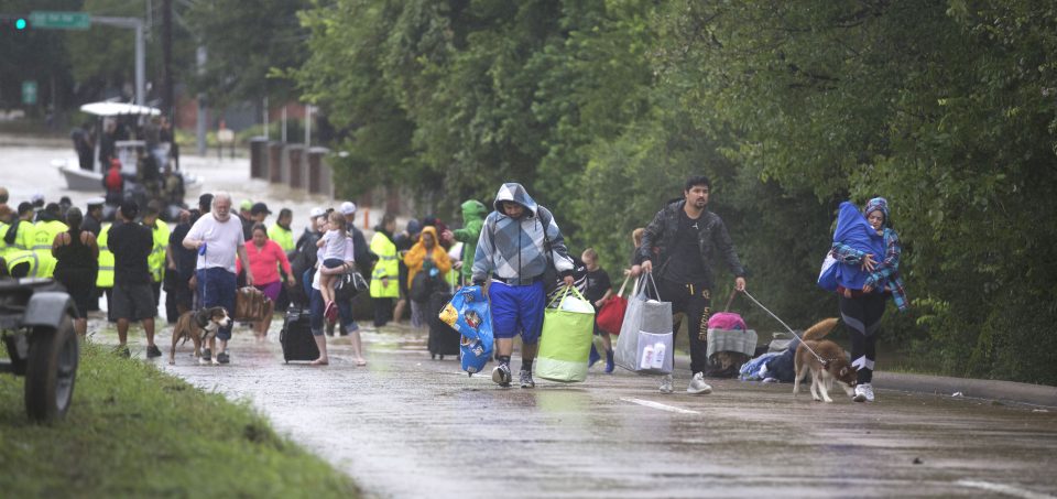 People carrying their belongings from boats to higher ground