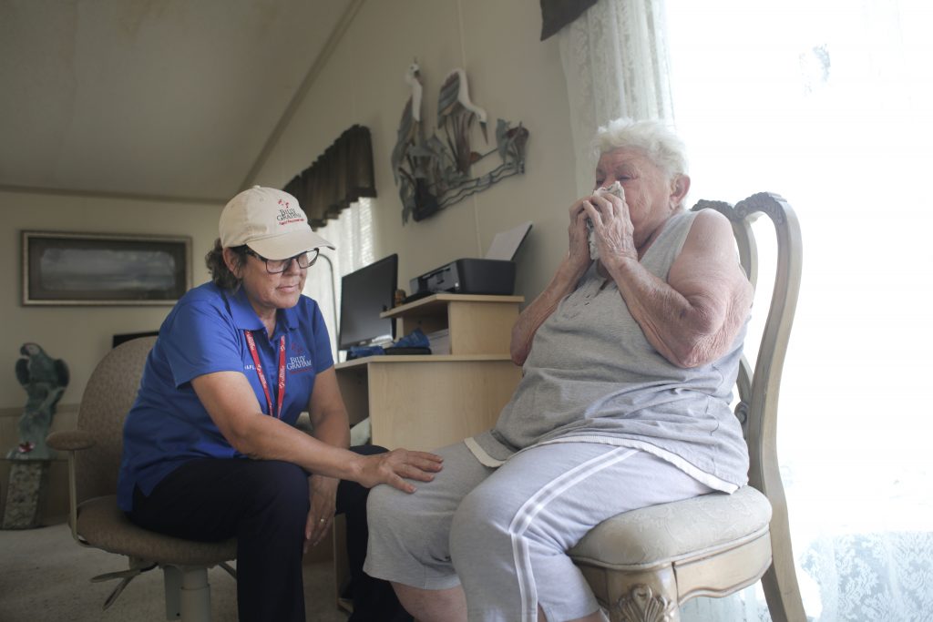 Female chaplain comforting a Naples resident who is crying