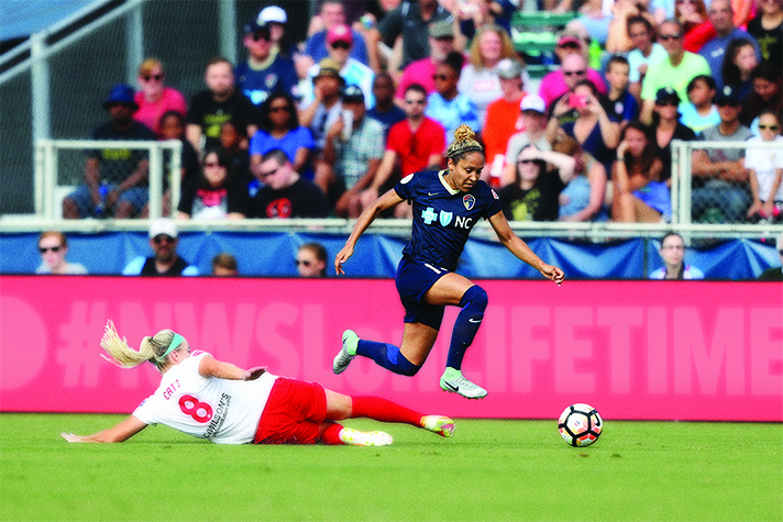 Jaelene Hinkle going for soccer ball during game