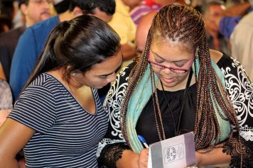 Counselor writing down info from young woman during invitation