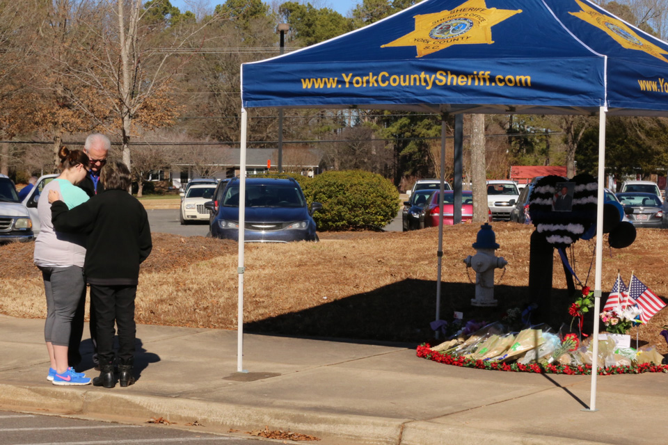 chaplains pray with a woman by Det. Doty's memorial tent