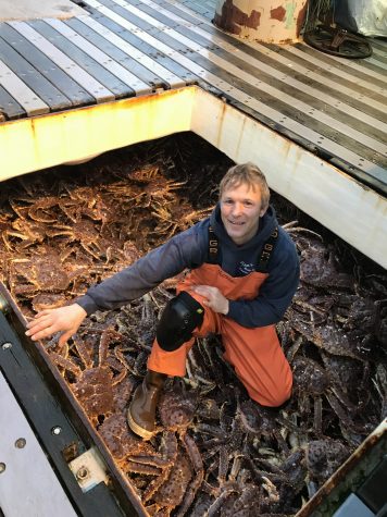 A man with a load of red king crabs
