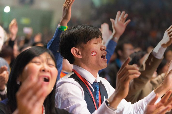 Man singing, hands raised