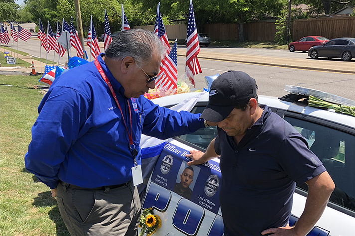 RRT chaplain prays with man in front of slain Officer Rogelio Santander's police cruiser