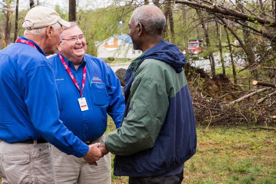 Two chaplains smiling and talking with a man