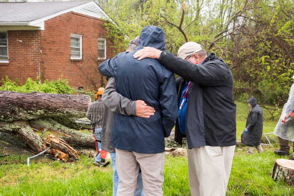 Chaplains praying with man