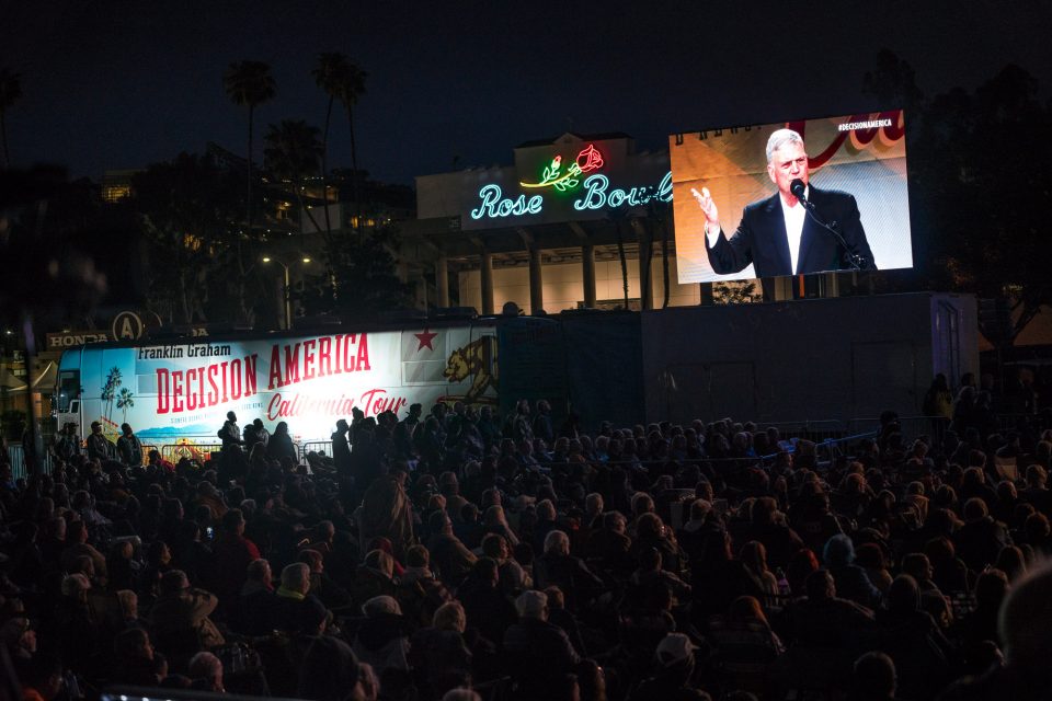 Franklin Graham on big screen with Decision California bus and Rose Bowl stadium in background